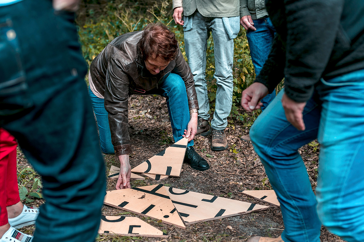 Collega's helpen elkaar tijdens een outdooractiviteit bij Landhuis de Oliphant in Rotterdam.